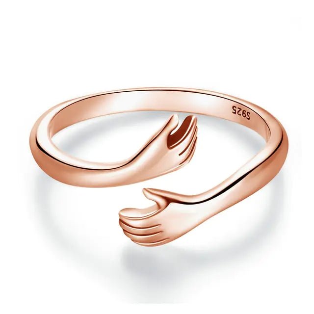A Rose Gold-plated sterling silver ring with an open design resembling an embrace.