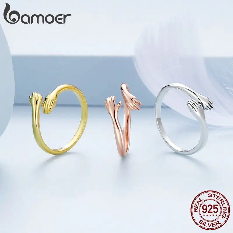 A three colored sterling silver rings with an open design resembling an embrace.