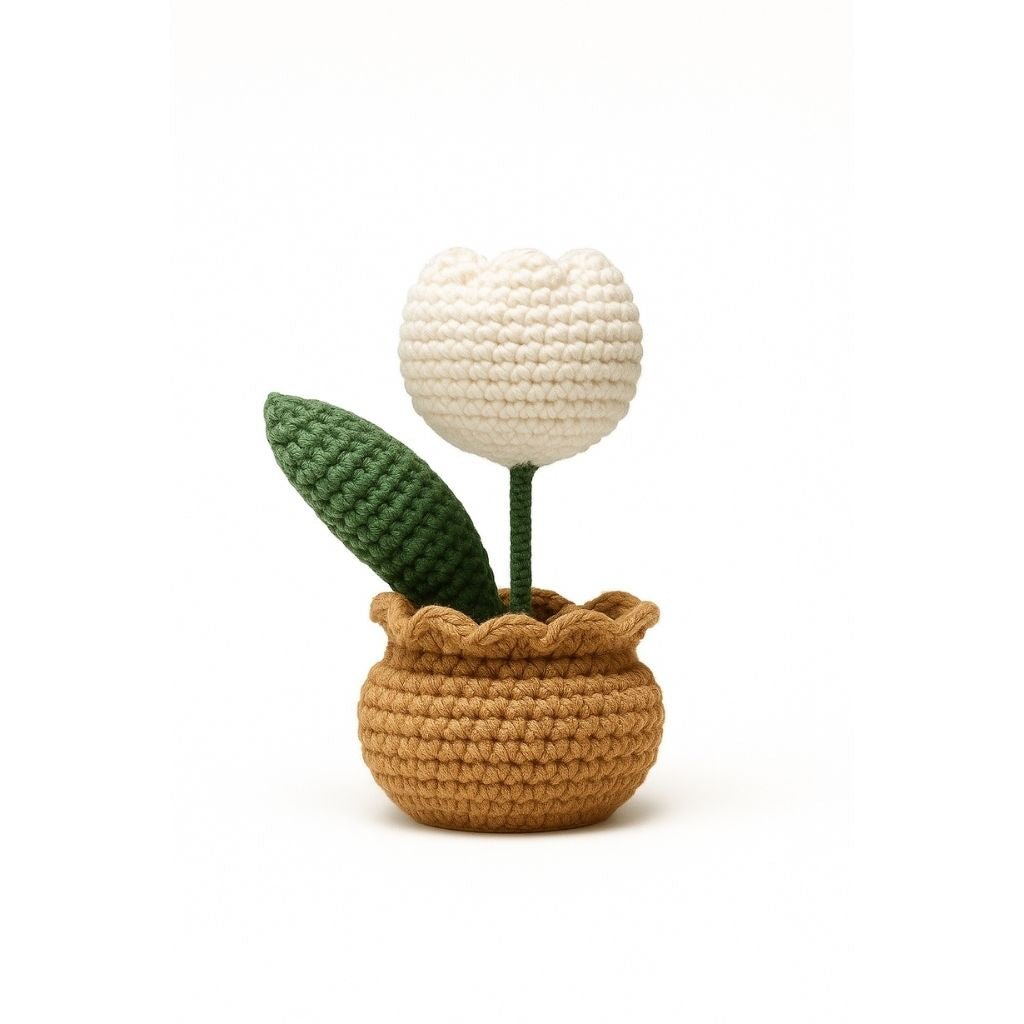Crocheted potted plant with a white flower and green leaves