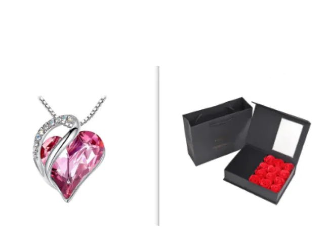 A set of a heart-shaped pendant necklace with a Pink crystal pendant surrounded by smaller clear crystal and a box.