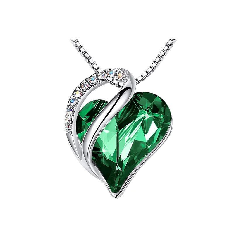 A heart-shaped pendant necklace with a Dark Green crystal pendant surrounded by smaller clear crystal.