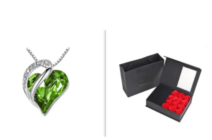A set of a heart-shaped pendant necklace with a Green crystal pendant surrounded by smaller clear crystal and a box.