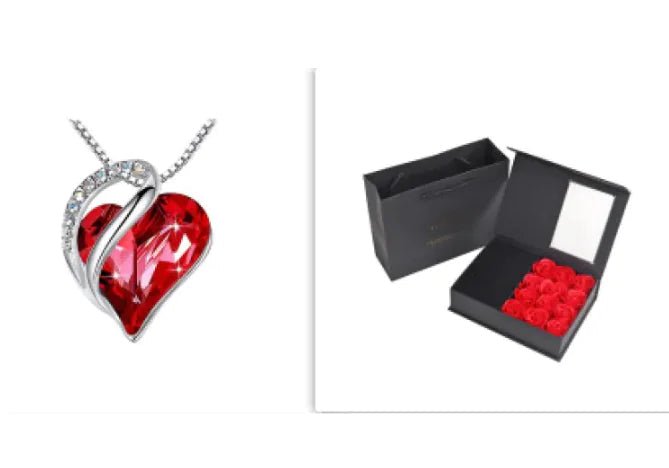 A set of a heart-shaped pendant necklace with a Red crystal pendant surrounded by smaller clear crystal and a box.