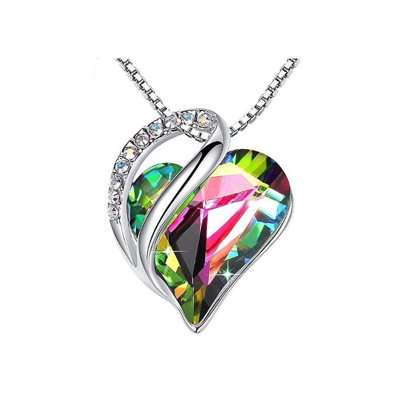 A heart-shaped pendant necklace with a Rainbow colored crystal pendant surrounded by smaller clear crystals.