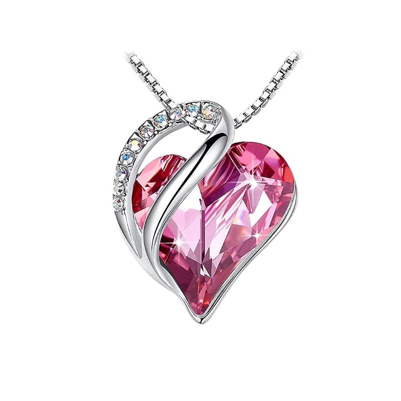 A heart-shaped pendant necklace with a Pink crystal pendant surrounded by smaller clear crystal.