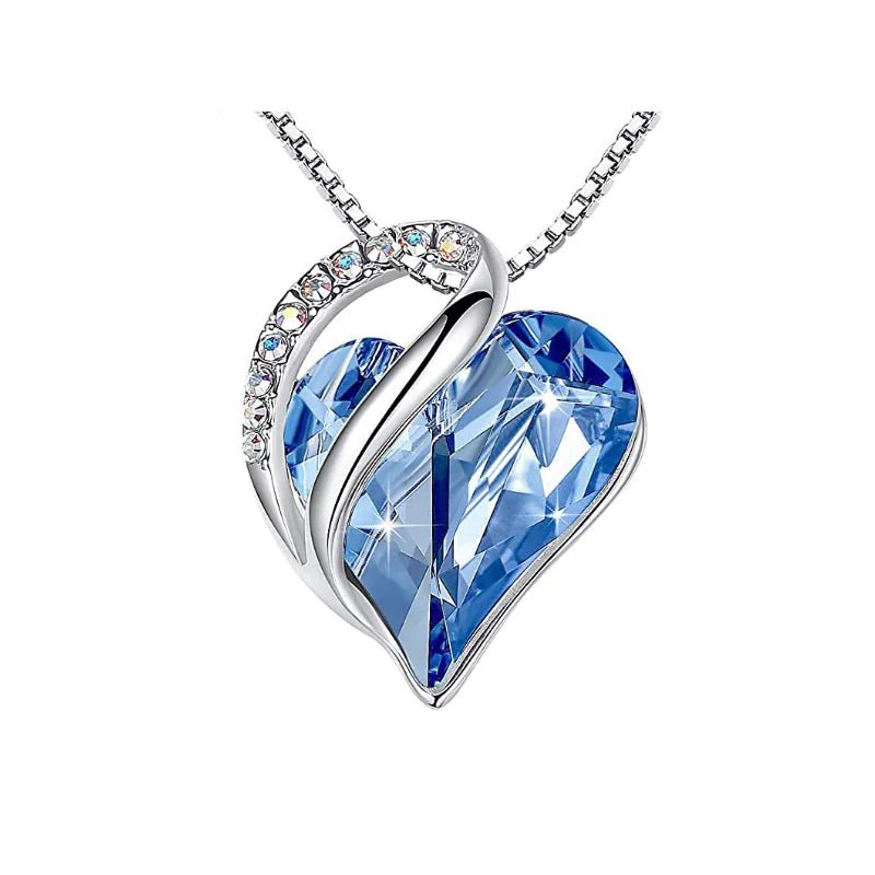 A heart-shaped pendant necklace with a Blue crystal pendant surrounded by smaller clear crystal.