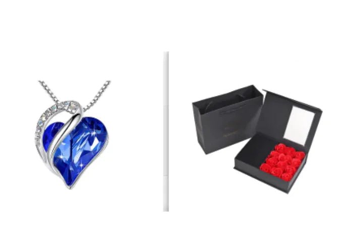 A set of a heart-shaped pendant necklace with a Royal Blue crystal pendant surrounded by smaller clear crystal and a box.