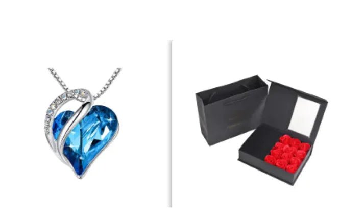 A set of a heart-shaped pendant necklace with a Sapphire Blue crystal pendant surrounded by smaller clear crystal and a box.