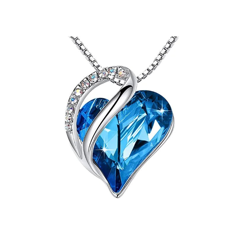 A heart-shaped pendant necklace with a Sapphire Blue crystal pendant surrounded by smaller clear crystal.