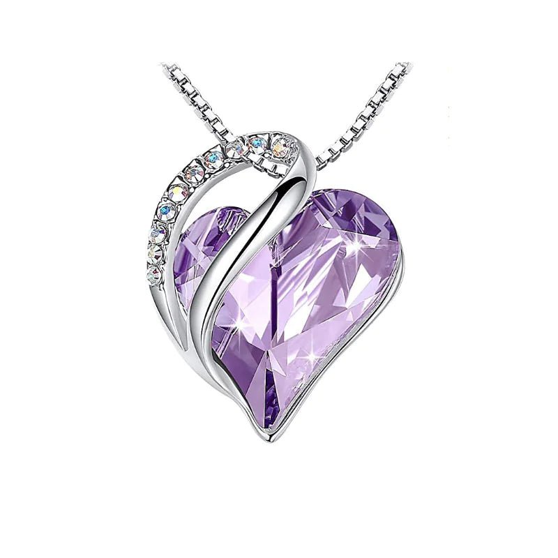 A heart-shaped pendant necklace with a Lavender crystal pendant surrounded by smaller clear crystal.