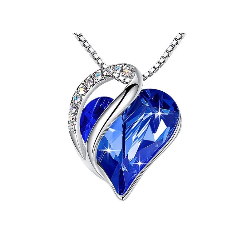 A heart-shaped pendant necklace with a Navy crystal pendant surrounded by smaller clear crystal.