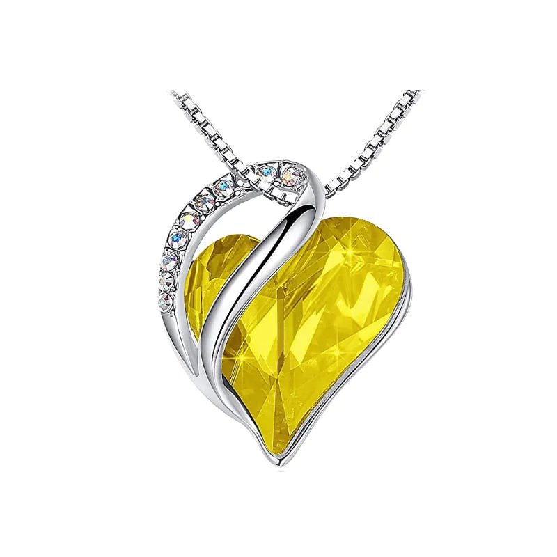 A heart-shaped pendant necklace with a Yellow crystal pendant surrounded by smaller clear crystal.