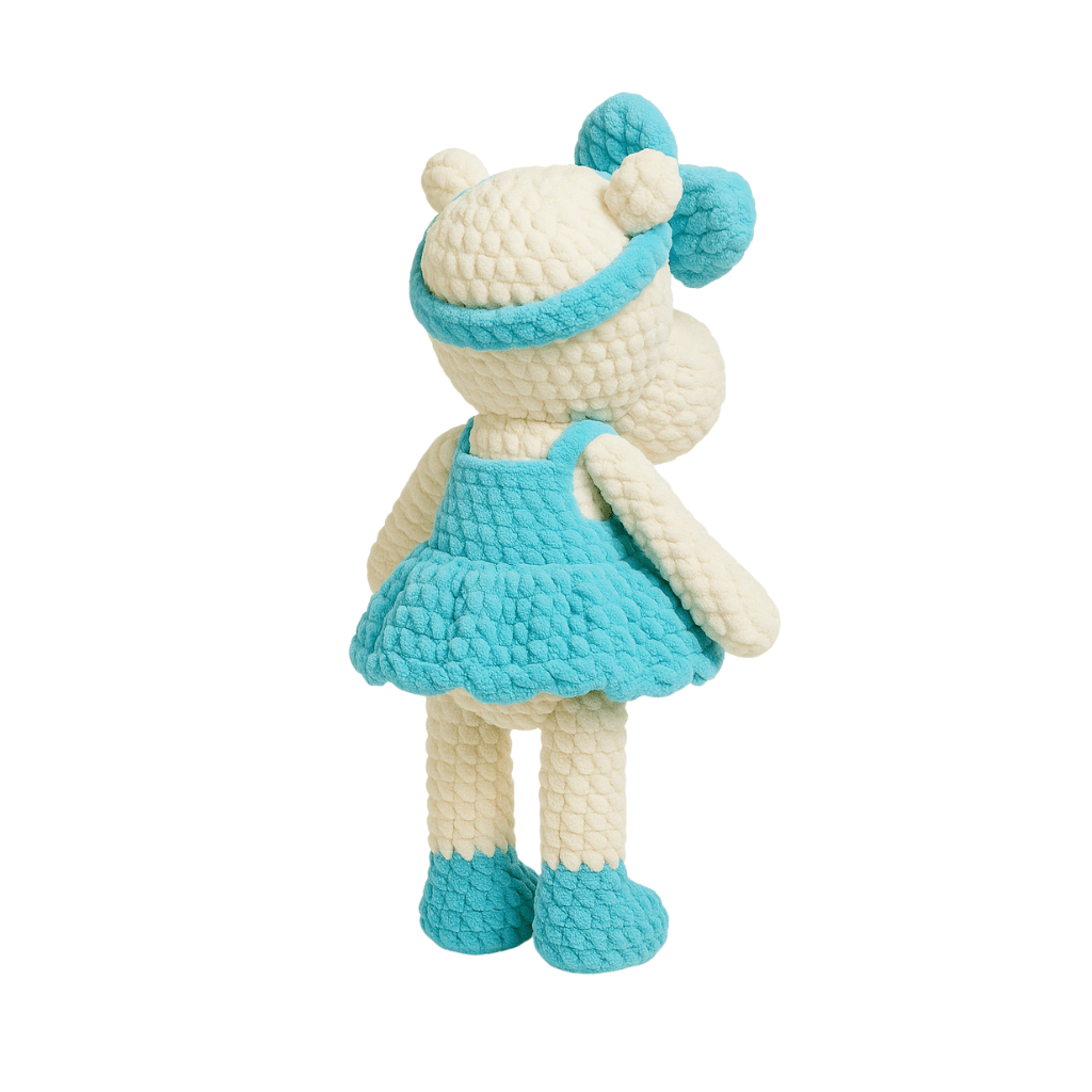 Handmade crochet doll in the shape of a hippopotamus wearing a teal dress and matching bow headband