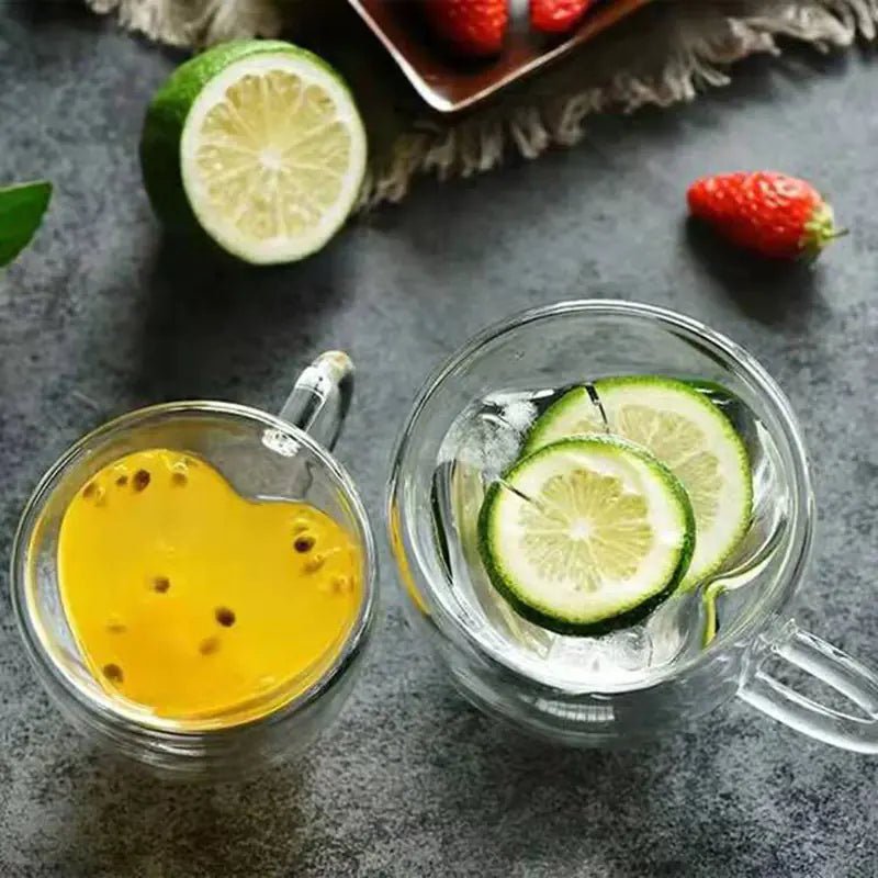 Two clear glass mugs with heart-shaped interiors with fruits beverage