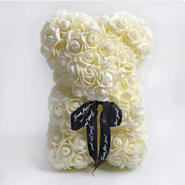 A teddy bear made from Beige artifical roses, with a black ribbon bow.