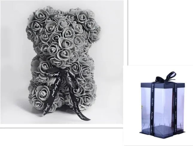 A teddy bear made from Grey artifical roses, with a black ribbon bow, comes with a box.