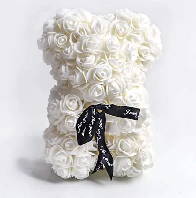 A teddy bear made from White artificial roses, with a black ribbon bow.