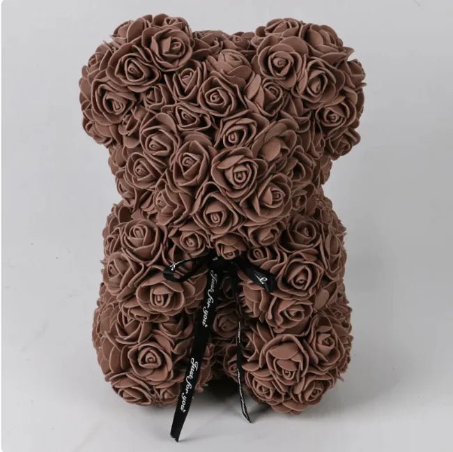 A teddy bear made from Coffee artifical roses, with a black ribbon bow.