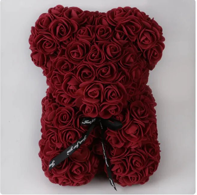 A teddy bear made from Wine Red artifical roses, with a black ribbon bow.