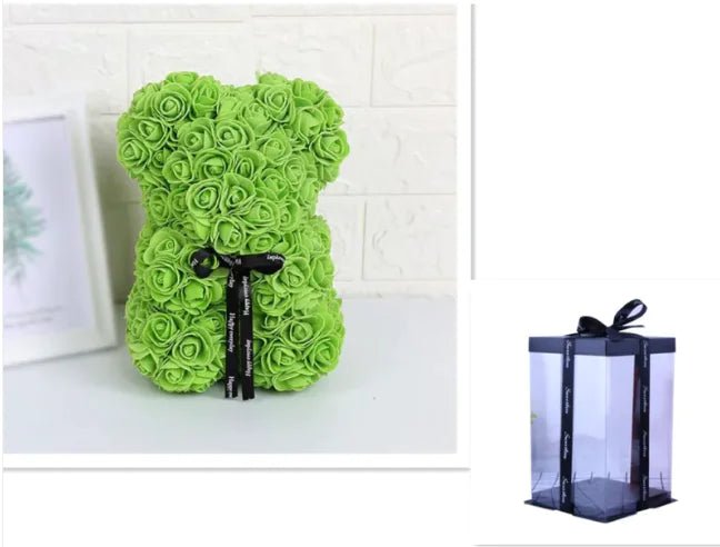A teddy bear made from Green artifical roses, with a black ribbon bow, comes with a box.