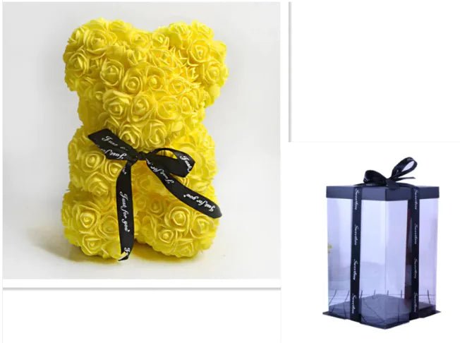 A teddy bear made from Yellow artifical roses, with a black ribbon bow, comes with a box.