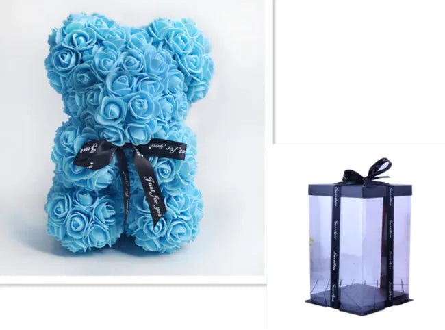 A teddy bear made from Sky blue artificial roses, with a black ribbon bow, comes with a box.