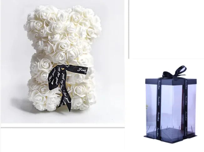 A teddy bear made from White artificial roses, with a black ribbon bow, comes with a box