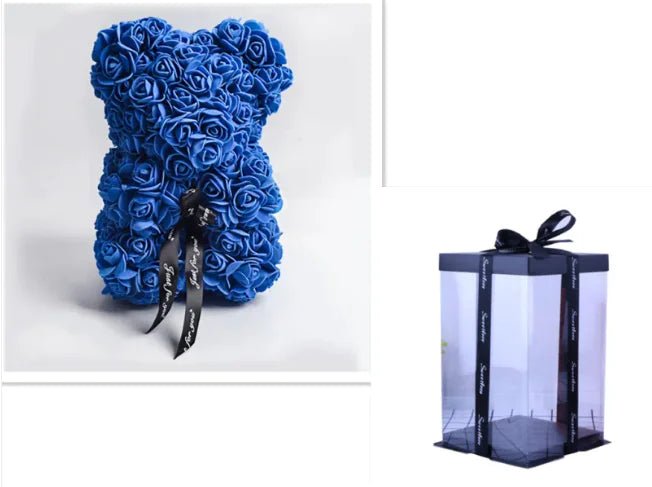 A teddy bear made from Royal Blue artificial roses, with a black ribbon bow, comes with a box.