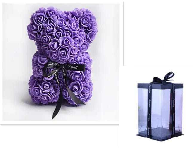 A teddy bear made from purple artificial roses, with a black ribbon bow, comes with a box.