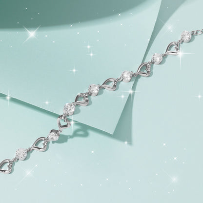 Silver bracelet with heart and leaf designs on a light blue background