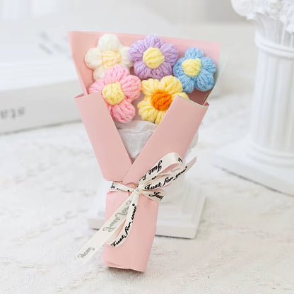 Pastel-colored knitted flowers in a pink box 
