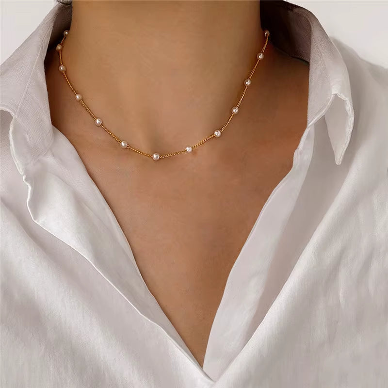Pearl necklace worn by a person wearing a white shirt
