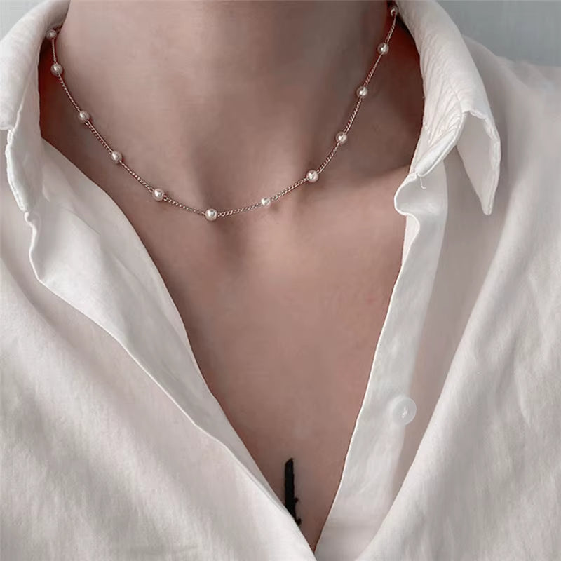 Pearl necklace worn by a person with a white shirt