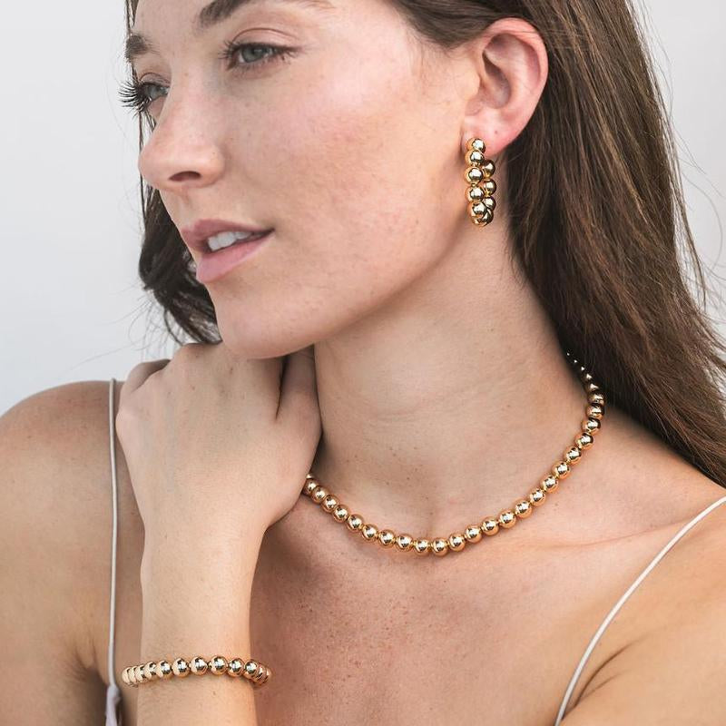 Woman wearing gold bead hoop earrings 