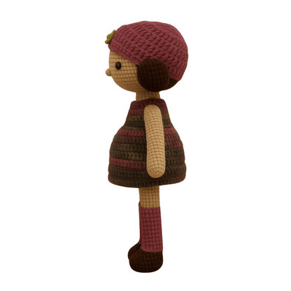 Handmade crochet doll with brown hair, wearing a purple striped dress and a matching beanie with a flower detail