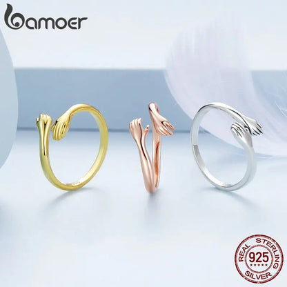 A three colored sterling silver rings with an open design resembling an embrace.