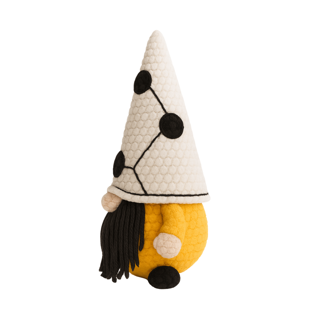 A handcrafted crochet gnome with a tall white hat with black dots, a mustard yellow body, and a black beard