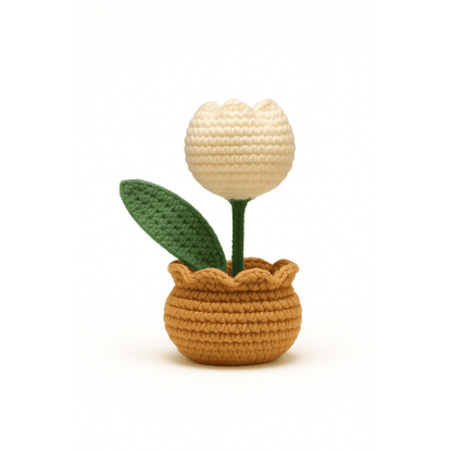 Crocheted potted plant with a beige flower and green leaves 