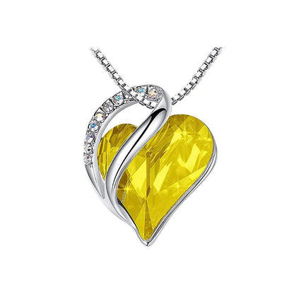A heart-shaped pendant necklace with a Yellow crystal pendant surrounded by smaller clear crystal.