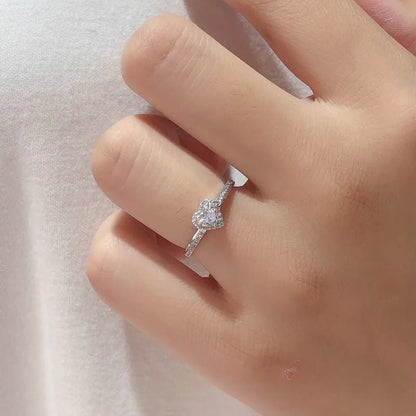 A sterling silver heart-shaped ring with a platinum-colored finish, shown on a hand.