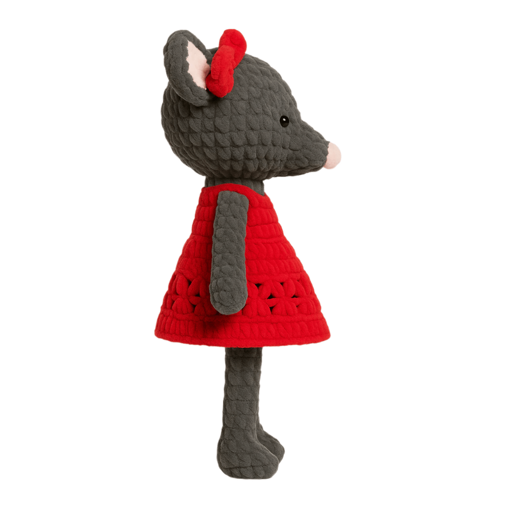Handmade crochet doll resembling a mouse with a gray body, pink nose, big ears, and a red dress with a bow