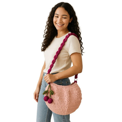 Woman holding a pink crochet bag with a purple strap