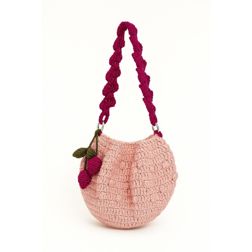 Pink handbag with a purple handle and cherry decoration
