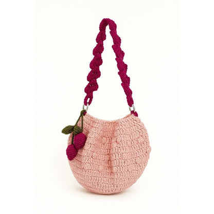 Pink handbag with a purple handle and cherry decoration