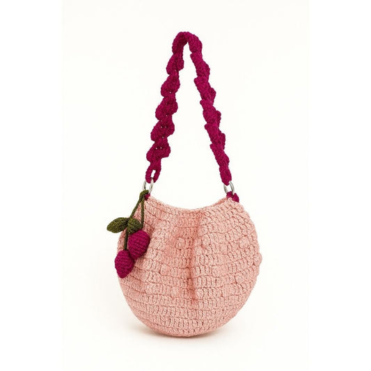 Pink handbag with a purple handle and cherry decoration