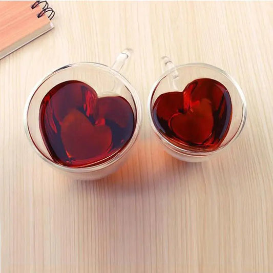 Two clear glass mugs with heart-shaped interiors 