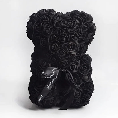 A teddy bear made from Black artifical roses, with a black ribbon bow.