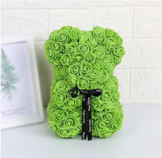 A teddy bear made from Green artifical roses, with a black ribbon bow.