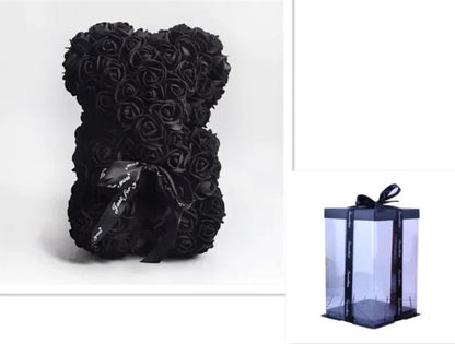 A teddy bear made from Black artifical roses, with a black ribbon bow, comes with a box.