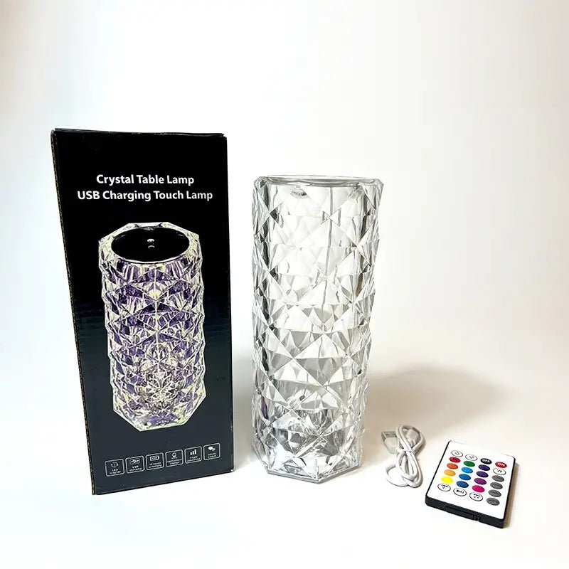A crystal table lamp with a USB charging cable and a remote control, displayed next to its packaging box.